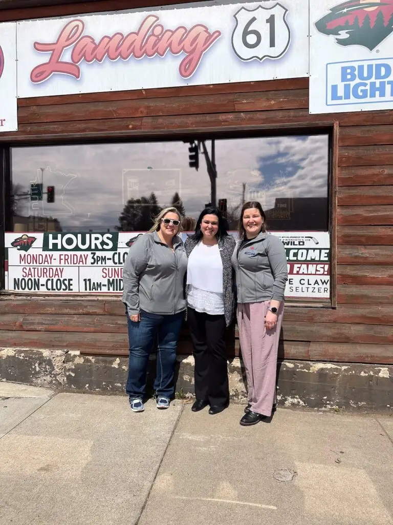 Trina Swanson and peers in front of shop