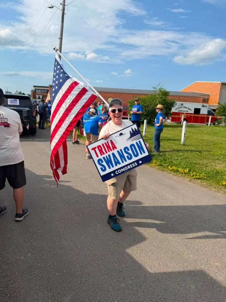 Man with a Trina Swanson for Congress sign.